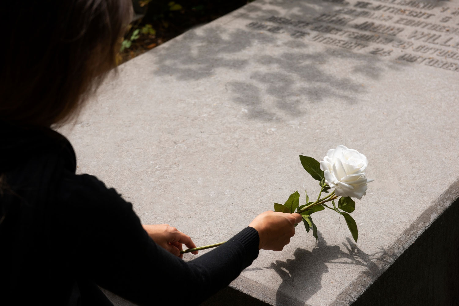 Uma imagem de mulher segurando uma rosa branca em homenagem para mãe falecida